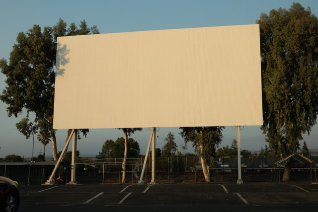 A traditional billboard in a car park.