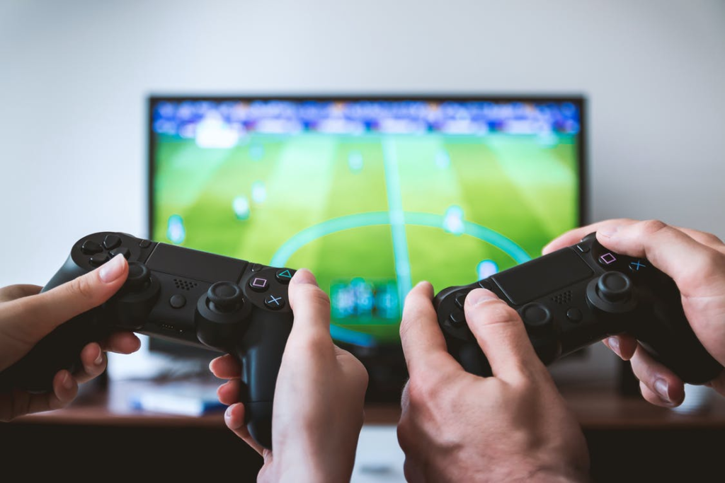 Two people holding controllers in front of a screen. 